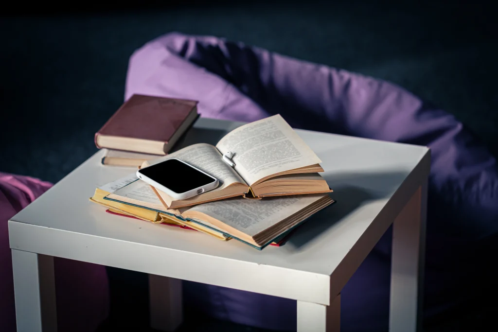Person searching under a table while books lie above, representing the importance of using professional book marketing services.